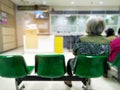 Old woman sit on green chair waiting medical and health services to the hospital