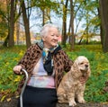 Old woman sitting on a bench with a dog Royalty Free Stock Photo