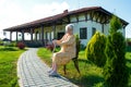 Old woman sitting on a chair with a cane Royalty Free Stock Photo