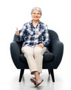 old woman sitting in chair and showing thumbs up Royalty Free Stock Photo