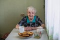 The old woman sitting at the kitchen table Royalty Free Stock Photo