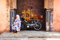 Old woman sitting next to the bike in Medina of Marrakesh, Morocco