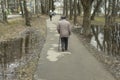 Old woman on street. Pensioner with walking stick