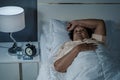 Old woman suffering from insomnia is trying to sleep in bed Royalty Free Stock Photo