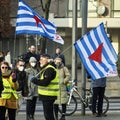 Old woman with sunglasses and old man with white beard raised blue-white flag with red triangle of antifascists