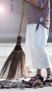 Old woman is sweeping dry leaf.