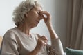 Old woman took off glasses to relief eyestrain feelings