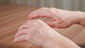 Old woman trembling wrinkled hands due to Parkinson disease