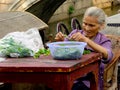 Old woman triming vegetables for cooking Royalty Free Stock Photo