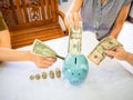 Old woman and two girls hands are putting bank note into blue piggy bank with golden coins graph, Saving money for future plan and Royalty Free Stock Photo