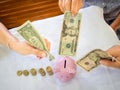 Old woman and two girls hands are putting bank note into pink piggy bank with golden coins graph, Saving money for future plan and Royalty Free Stock Photo