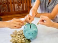 Old woman and two girls hands are putting golden cions into blue piggy bank, Saving money for future plan and retirement fund Royalty Free Stock Photo