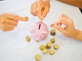 Old woman and two girls hands are putting golden cions into pink piggy bank, Saving money for future plan and retirement fund Royalty Free Stock Photo