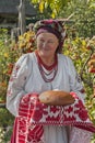 The old woman in Ukrainian national costume presents guests with bread in salt