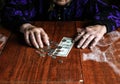 Old woman with very little money. Poverty concept. Pensioner with one dollar note and coins in hands. Economy and crisis in the Royalty Free Stock Photo