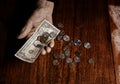 Old woman with very little money. Poverty concept. Pensioner with one dollar note and coins in hands. Economy and crisis in the Royalty Free Stock Photo