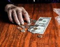 Old woman with very little money. Poverty concept. Pensioner with one dollar note and coins in hands. Economy and crisis in the Royalty Free Stock Photo