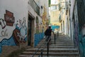 An old woman walking in in a street with Graffiti and Street art. Lisbon, Portugal Royalty Free Stock Photo