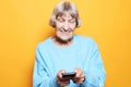 Old woman wearing blue sweater talking on cell phone Royalty Free Stock Photo