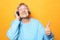 Old woman wearing blue sweater  talking on cell phone Royalty Free Stock Photo