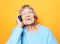 Old woman wearing blue sweater talking on cell phone Royalty Free Stock Photo