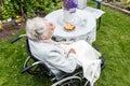 Old woman in a wheelchair drinking tea on the terrace Royalty Free Stock Photo