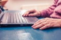 Old woman working on laptop computer at home Royalty Free Stock Photo