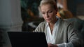 Old woman working laptop computer at home. Elderly lady looking laptop Royalty Free Stock Photo