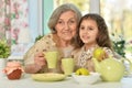 Old woman with a young girl drinking tea on the table Royalty Free Stock Photo
