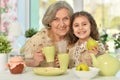 Old woman with a young girl drinking tea on the table Royalty Free Stock Photo