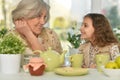 Old woman with a young girl drinking tea on the table Royalty Free Stock Photo