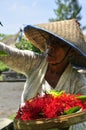 Old women with asian hat making offers to Gods