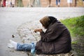 Old women beggar sitting lonely at pathway for begging money fro