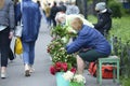 Old women flower sellers sell flowers on the street of the city, people passing by. Kyiv, Ukraine