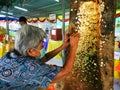 old women paste gold leaf on monk to make merit for buddhism in Thailand