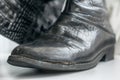 Old women`s boots with side damage made of genuine leather imitating a crocodile pattern Royalty Free Stock Photo