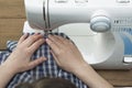 Old women`s hands behind her sewing in sewing machine