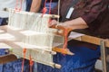 Old women are using the machine - Household Loom weaving - for homemade silk or textile