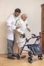 Male nurse helps the old lady to walk with the help of a walker, a balcony.