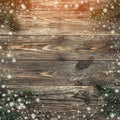 Old wood background with fir branches. Space for a greeting message. Christmas card. Top view. Effect of light and snowflakes Royalty Free Stock Photo