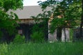 Old wood barn partially hidden behind green trees Royalty Free Stock Photo