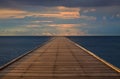 Old wood bridge to the sea with cloudy sky Royalty Free Stock Photo