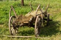 old wood hay-wagon coach wheel in grass Royalty Free Stock Photo