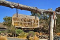 old wood signboard with text welcome to Henderson. hanging on a branch