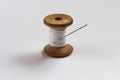 Old wood spool with white thread and needle Royalty Free Stock Photo