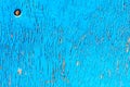 Old wood surface with blue paint flaking and cracking background texture.