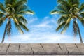 Old wood table top with coconut trees and blue sky background. Royalty Free Stock Photo