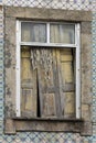 Old wood window half open. Blue portuguese tiles