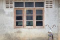 Old wood windows on the cement wall of the house and old bicycle Royalty Free Stock Photo