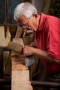 Old woodcarver working with mallet Royalty Free Stock Photo